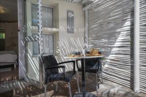 Apartment Melkbos Moments في مليكبوستراند: طاولة وكراسي في غرفة بها جدار