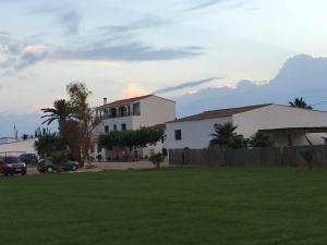 L'Aldea的住宿－Masia Botargo，白色的房子,有栅栏和草地