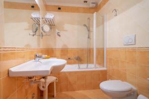 a bathroom with a sink and a toilet and a shower at Hotel Capri Bardolino 3S in Bardolino