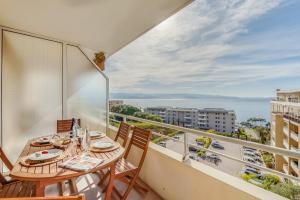 een balkon met een tafel en stoelen en uitzicht op de oceaan bij Cappella in Ajaccio
