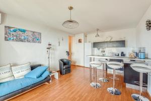 een woonkamer met een blauwe bank en een keuken bij Cappella in Ajaccio +7 foto's