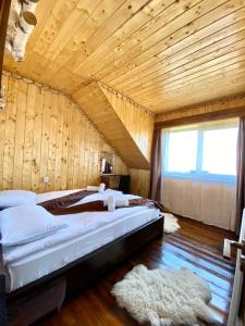 Cama grande en habitación con techo de madera en Casa Margau, en Mărgău