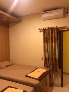 een slaapkamer met een bed en airconditioning aan de muur bij Kangen Yogya Homestay Malioboro Mitra RedDoorz in Yogyakarta