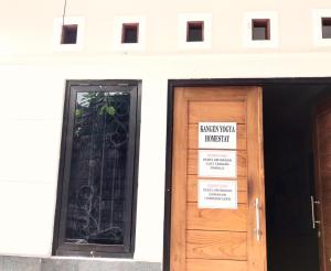 a building with a door with a sign on it at Kangen Yogya Homestay Malioboro Mitra RedDoorz in Yogyakarta