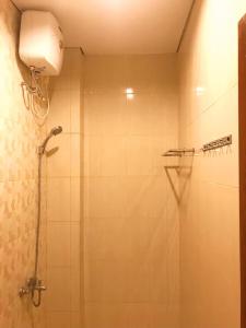 y baño con ducha con cabezal de ducha. en Kangen Yogya Homestay Malioboro Mitra RedDoorz en Yogyakarta