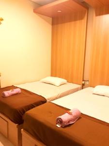 two beds in a room with two pink towels on them at Kangen Yogya Homestay Malioboro Mitra RedDoorz in Yogyakarta