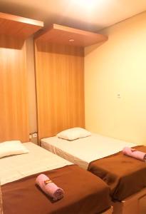 a room with two beds in a room at Kangen Yogya Homestay Malioboro Mitra RedDoorz in Yogyakarta