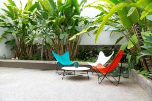 trois chaises et une table devant des plantes dans l'établissement Luxury modernist design townhouse with garden, à Santa Cruz de Tenerife