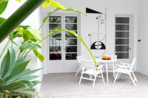 un patio avec une table, des chaises et des plantes dans l'établissement Luxury modernist design townhouse with garden, à Santa Cruz de Tenerife