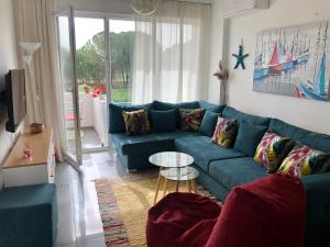 a living room with a blue couch and a table at Hanah Apartment - Gjiri Lalzit Lura 3 in Mullini i Danit