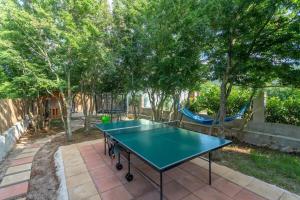una mesa de ping pong en un patio trasero con árboles en Holiday Home Sunrise, en Kraj