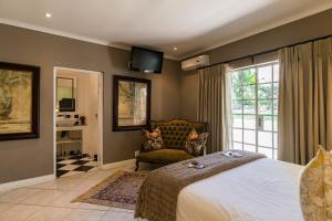 um quarto com uma cama, uma cadeira e uma janela em Duke & Duchess Boutique Hotel em Pretoria