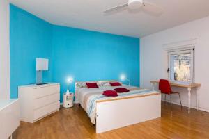 Dormitorio azul con cama y pared azul en Torbole Holiday House Appartamento con giardino, en Nago-Torbole