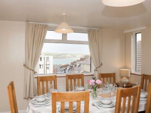 a dining room with a table and a large window at Seaview in Swanage