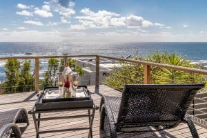 balkon ze stołem i krzesłami oraz oceanem w obiekcie 51 On Camps Bay w Kapsztadzie