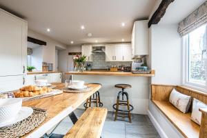 eine Küche mit einem Holztisch mit Brot darauf in der Unterkunft Hilldale Cottage in Earl Sterndale