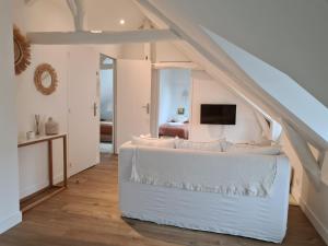 a bedroom with a white bed and a tv at Santorin, Appartement lumineux au coeur de Vannes in Vannes