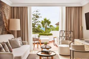 a living room with a white couch and chairs at Puente Romano Marbella in Marbella