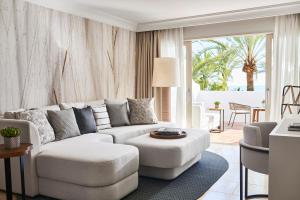 a living room with a white couch and a table at Puente Romano Marbella in Marbella