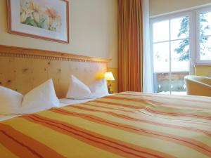 a hotel room with a large bed and a window at Hotel Sportalm in Gerlos