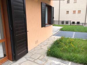 an open door of a building with a grass yard at I Cirmoli in Bormio