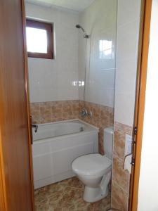 a bathroom with a toilet and a tub and a sink at Triumph Holiday Village in Sveti Vlas