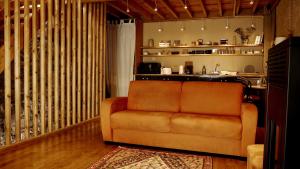 un sofá en una sala de estar con en Le petit gîte de Maurenne, en Hastière-Lavaux