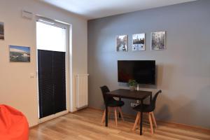 a dining room with a table and chairs and a television at Studio Aparatka in Warsaw