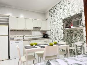 eine Küche mit weißen Schränken und einem Tisch und Stühlen in der Unterkunft Apartamentos Centro del VINO Tandal in Ronda