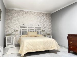 a white bedroom with a bed and a wall at Apartamentos Centro del VINO Tandal in Ronda