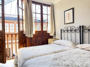 ein Schlafzimmer mit einem Bett und einem großen Fenster in der Unterkunft Apartamentos Centro del VINO Tandal in Ronda