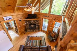 uma vista superior de uma sala de estar com uma lareira de pedra em Nestled In Secluded Cabin in the Mountains with Hot Tub, Fire Pit, and SEGA Game System! em Sevierville