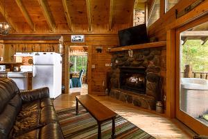 a living room with a couch and a fireplace at Nestled In Secluded Cabin in the Mountains with Hot Tub, Fire Pit, and SEGA Game System! in Sevierville