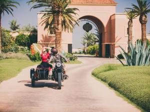 Un uomo e una donna che cavalcano su una moto di Fairmont Royal Palm Marrakech a Marrakech
