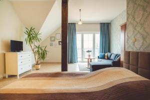 a bedroom with a large bed and a living room at PARADISE Apartamenty in Charzykowy