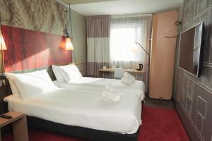 a hotel room with a large bed and a large window at ibis Glasgow City Centre – Sauchiehall St in Glasgow