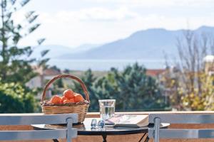 a basket of fruit sitting on a table with a glass at Angelina Boutique Escape in Perdika