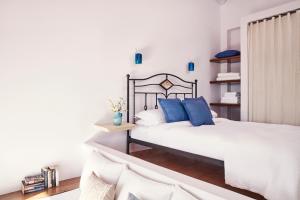 a bedroom with two beds with blue pillows at Angelina Boutique Escape in Perdika