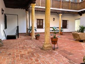 a courtyard with columns and potted plants in a building at Apartamentos Centro del VINO Tandal in Ronda