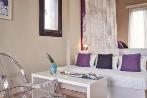 a living room with a white couch and purple pillows at Angelina Boutique Escape in Perdika