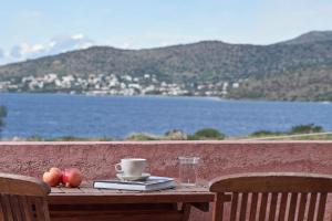 a table with apples and a cup of coffee on it at Angelina Boutique Escape in Perdika