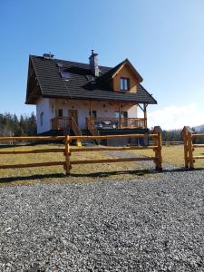 una valla de madera frente a una casa en Apartament z kominkiem i wanną en Istebna