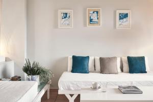 a white bedroom with blue pillows on a bed at Angelina Boutique Escape in Perdika