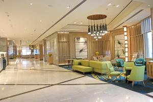 a lobby with chairs and tables and a chandelier at Holiday Inn Chandigarh Zirakpur, an IHG Hotel in Chandīgarh