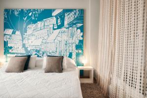 a bedroom with a bed with a blue and white wall at Angelina Boutique Escape in Perdika
