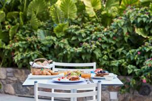 a table with two chairs with food on it at Angelina Boutique Escape in Perdika