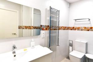 a bathroom with a sink and a toilet and a mirror at Nuevo - Moderno y cómodo apartamento en la playa in Somo +8 photos