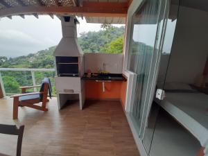 une petite cuisine avec une cuisinière dans une maison dans l'établissement Chalé Sasaki Ilhabela, à Ilhabela