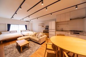 東京的住宿－NIYS apartments 08 type，厨房以及带桌子和沙发的客厅。