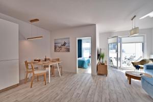Apartament Nadmorskie Tarasy SPA Deluxe في كولوبرزيغ: غرفة معيشة بيضاء مع طاولة وأريكة